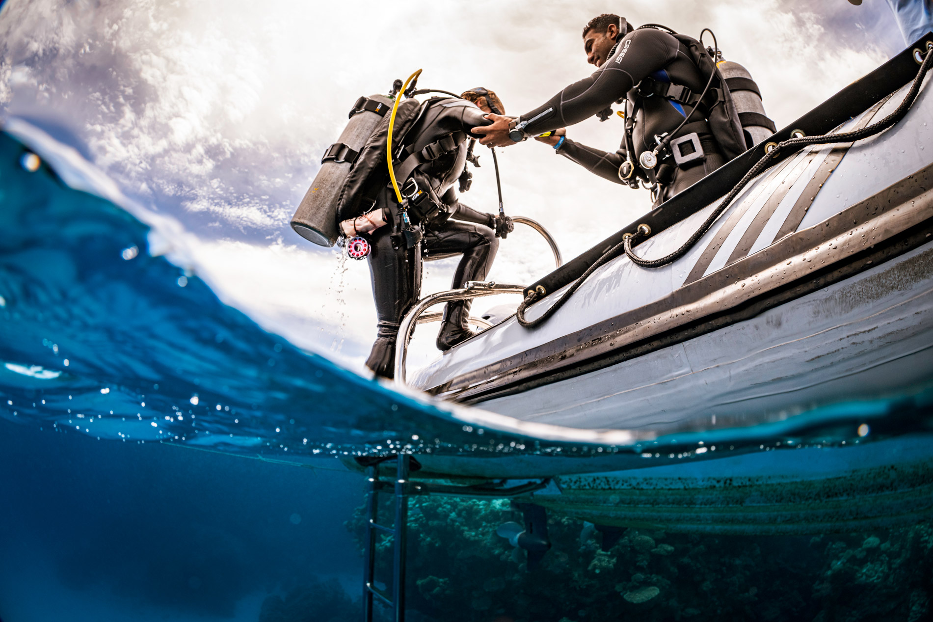 Divers getting off the boat to dive.