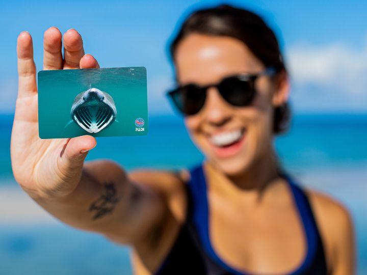 Person holding new Basking in the Moment by Alex Mustard PADI Certification Card