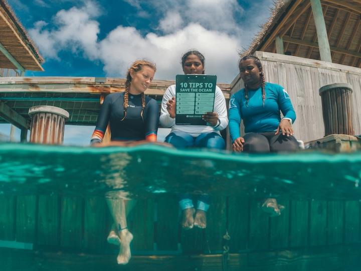 Three people looking over a PADI brochure.