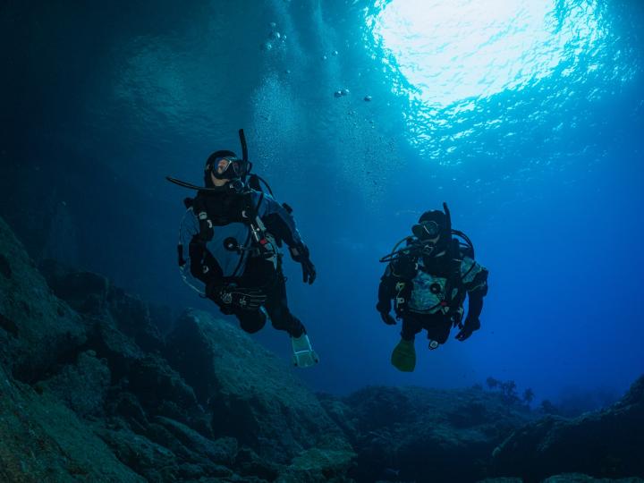 Two divers swimming in the ocean.