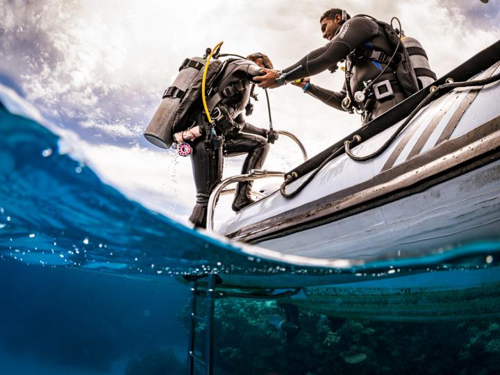 Divers getting off the boat to dive.