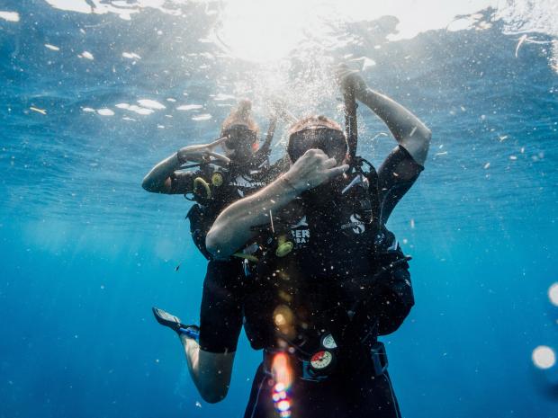 Two divers descending underwater