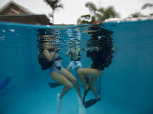 A group of three learning how to scuba dive.