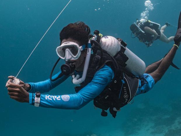 A diver holding a dsmb reel