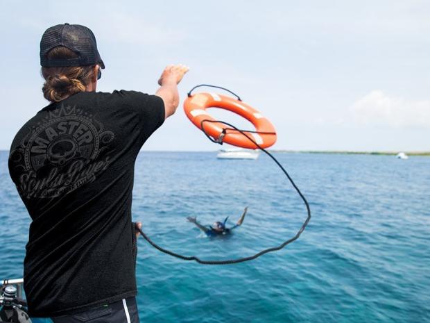 A person tossing a tube from the boat.