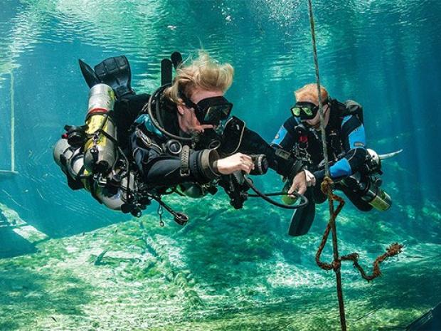 Tec divers with sidemount tanks doing safety stop